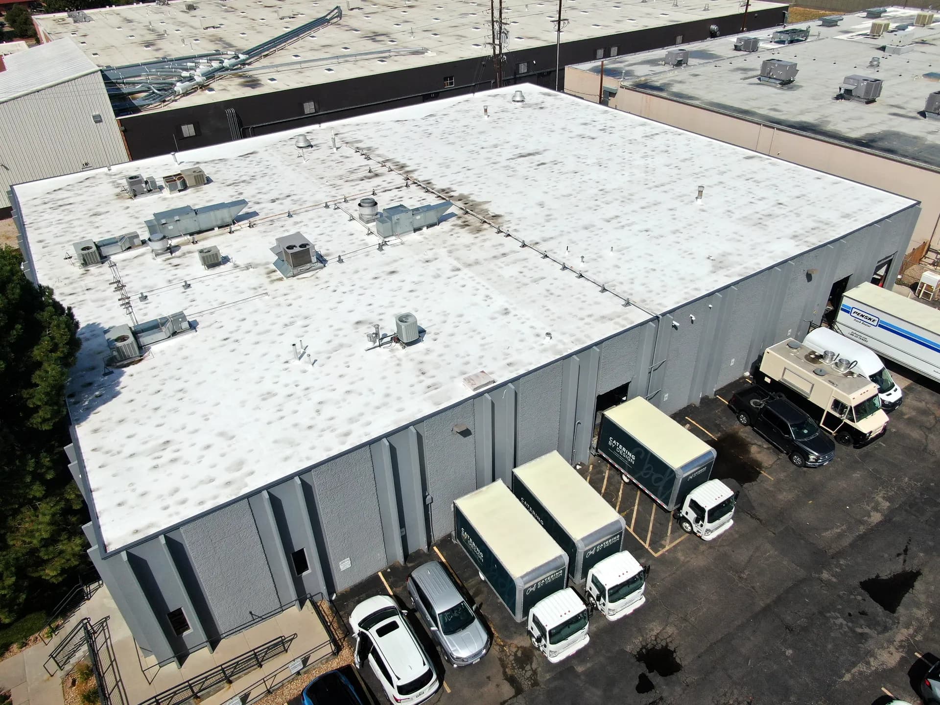 Aerial drone view of a completed commercial TPO roof replacement on an industrial warehouse in Denver, Colorado