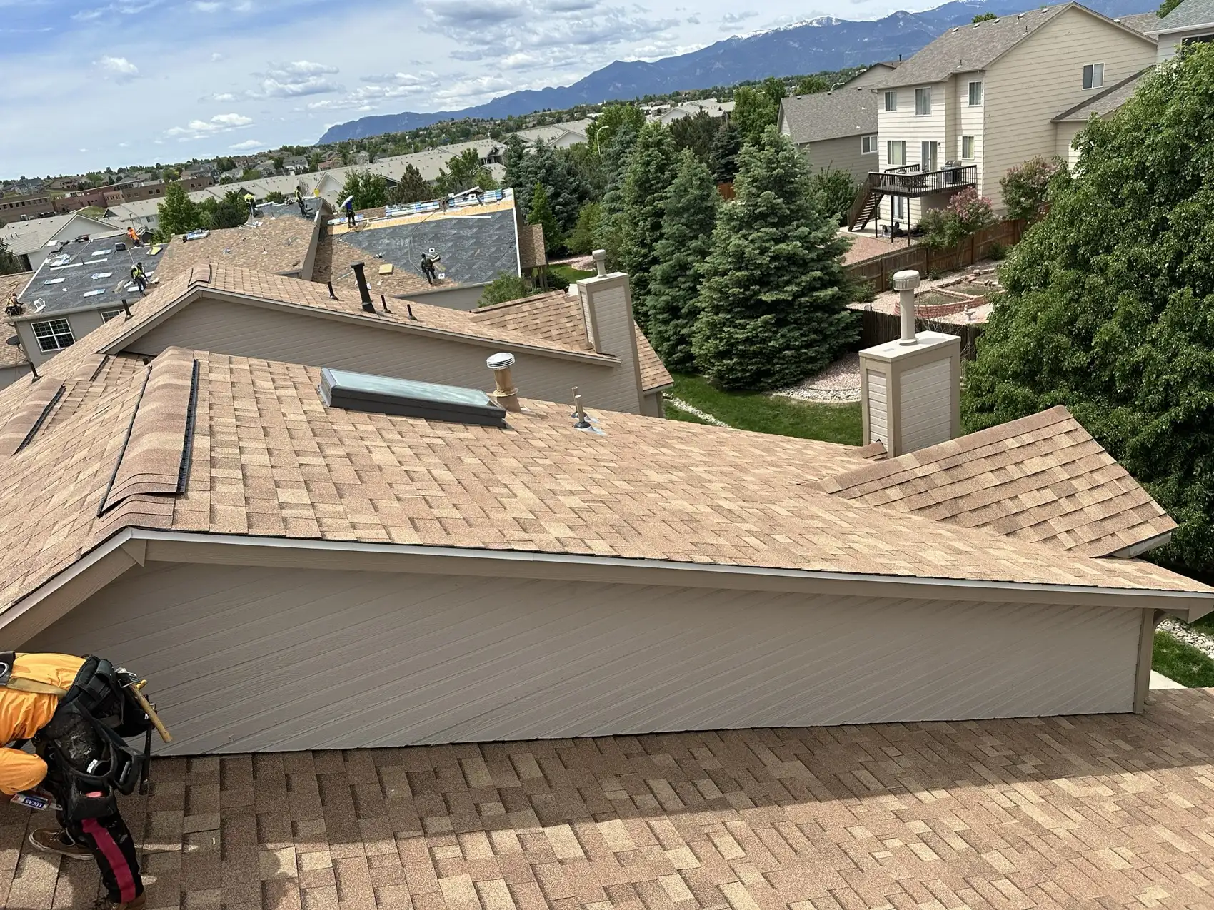 Completed Malarkey Vista AR shingle roof on a Colorado Springs condominium building with the Front Range mountains behind it