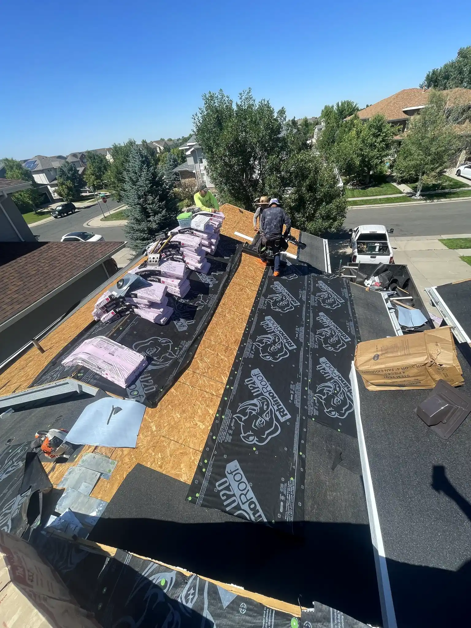 CRC roofing crew installing new shingles during a roof replacement on a home in Aurora, Colorado