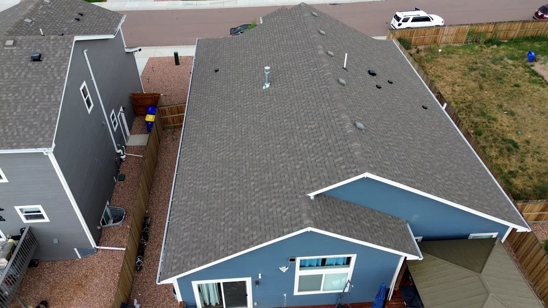 Aerial view of a completed architectural asphalt shingle roof on a two-story home in Colorado Springs, Colorado, after a hail insurance reroof