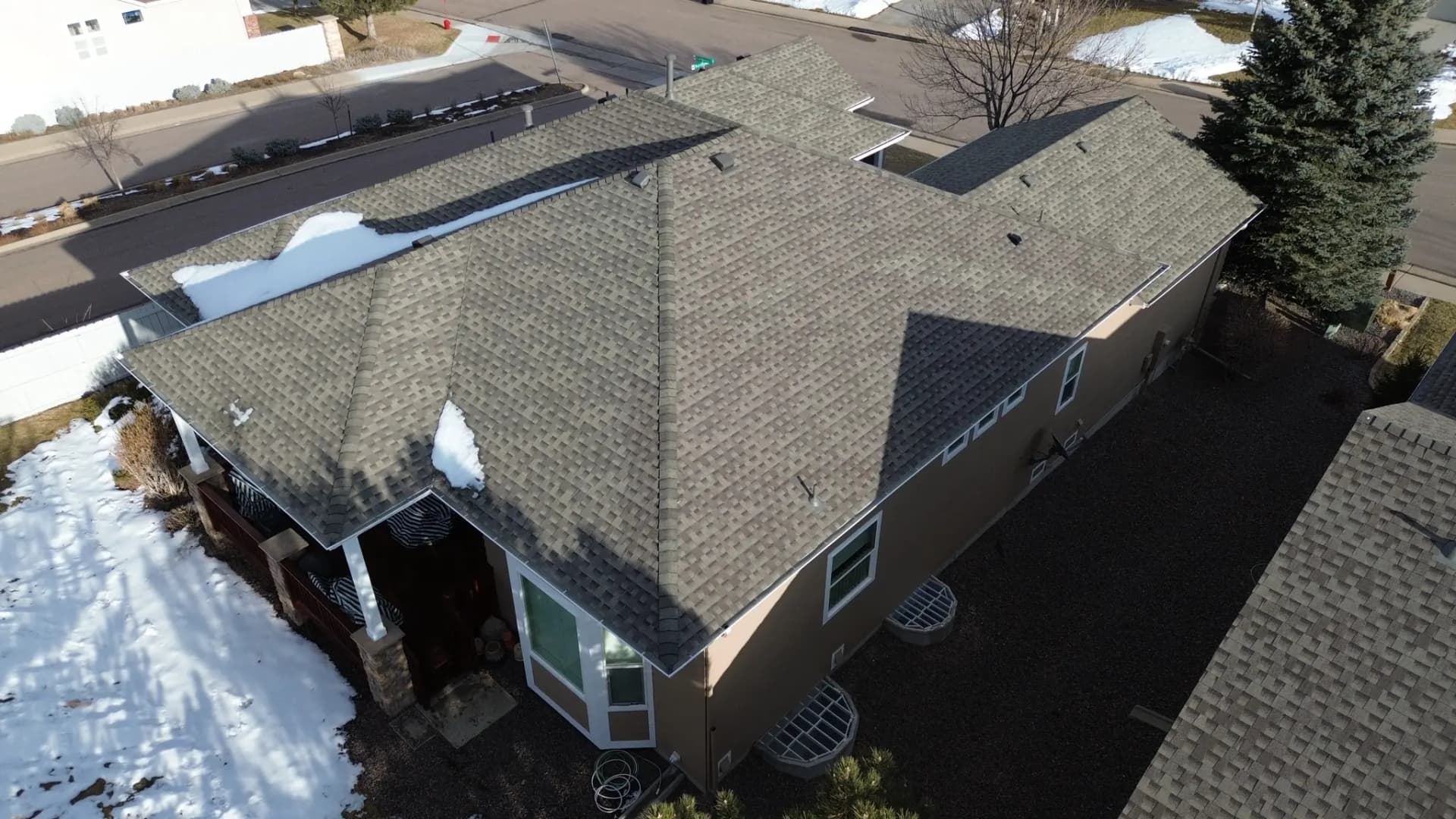 Aerial view of a completed GAF Timberline AS II Class 4 shingle roof in Weathered Wood on a home in Castle Pines, Colorado, with a freshly re-stained deck below