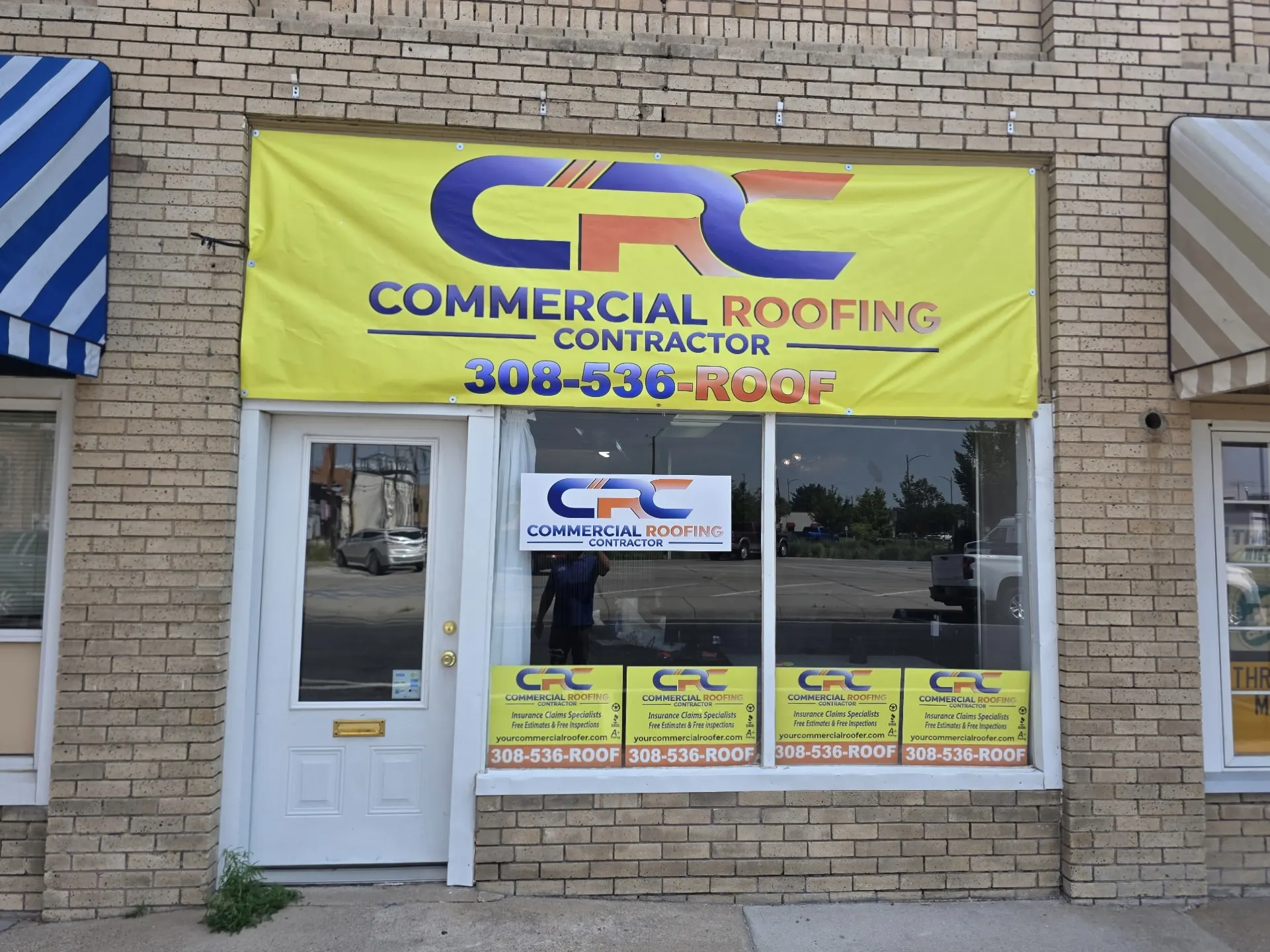 The Commercial Roofing Contractor Scottsbluff office storefront, with the company banner and phone number above the entrance