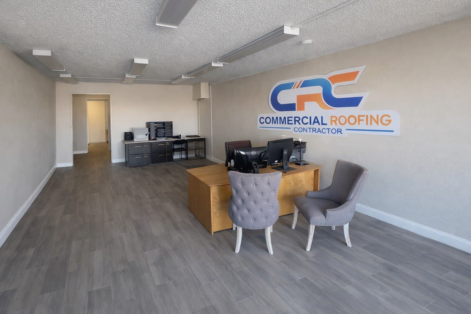 The reception area of the Commercial Roofing Contractor Grand Junction office, with the company logo on the wall